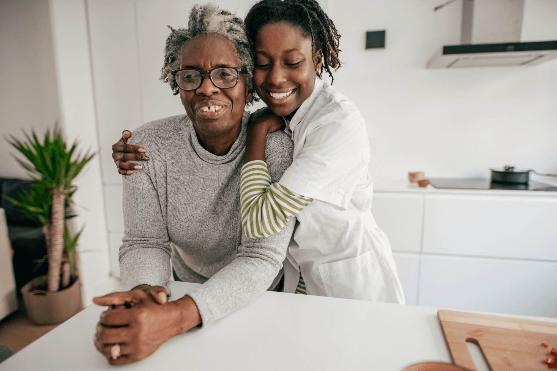 A caregiver offering warm support to an elderly client at home