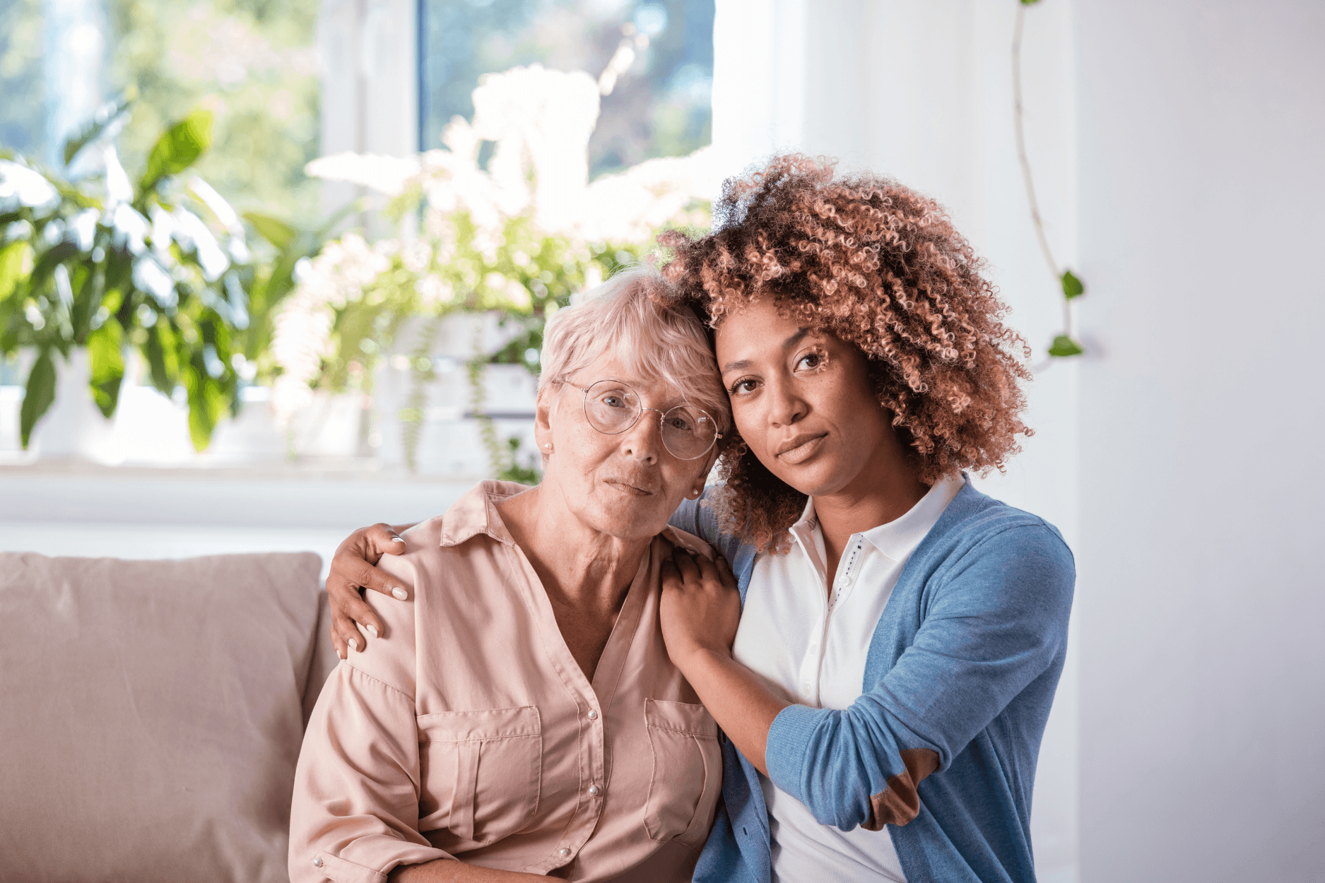 A caregiver embracing an elderly woman at home, conveying comfort and trust